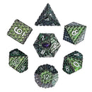 Set of green and black polyhedral dice on a white background